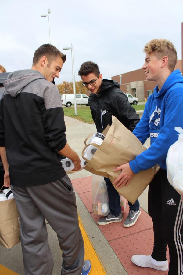 Brock Schultz and Jacob Shirley makes jokes while getting donations loaded into the pick-up truck.