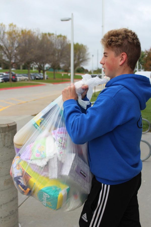 Jacob Shirley carries bags of non-perishables to a vehicle. 
