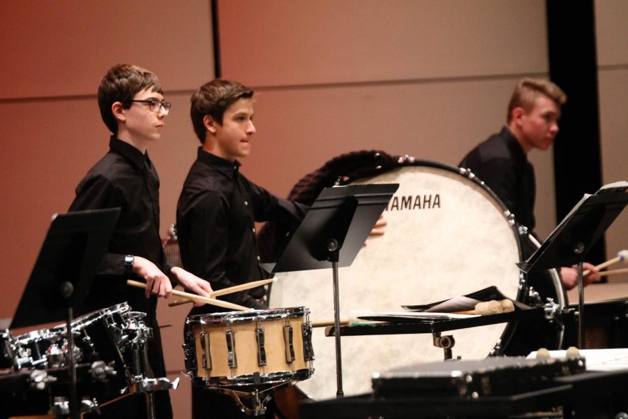 Percussionists stand tall in the back.