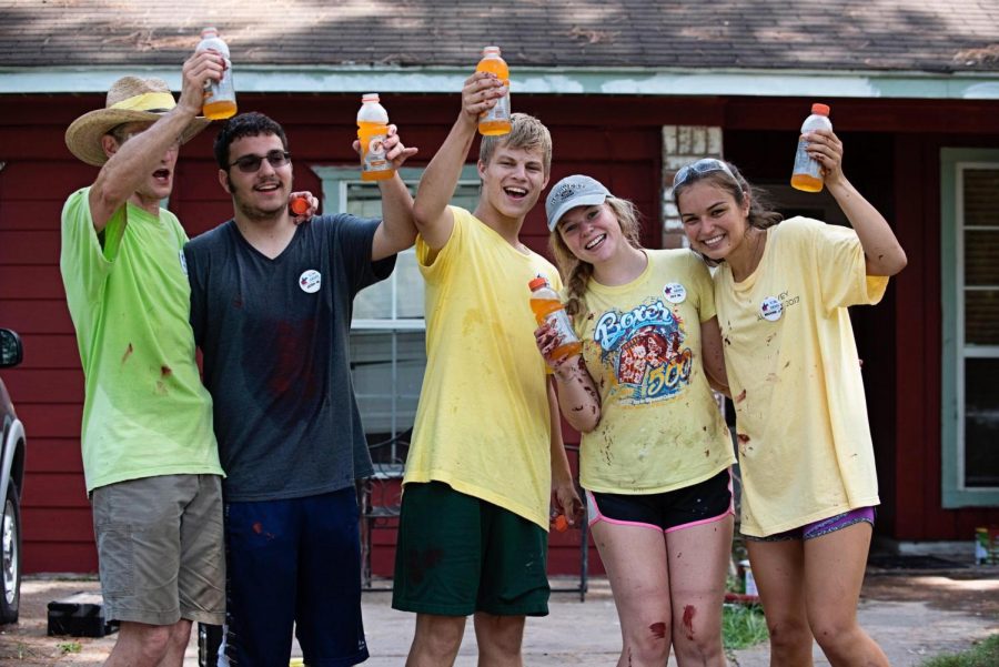 Student volunteers take a  break from painting houses in Pasadena, Texas, during a church mission trip. 