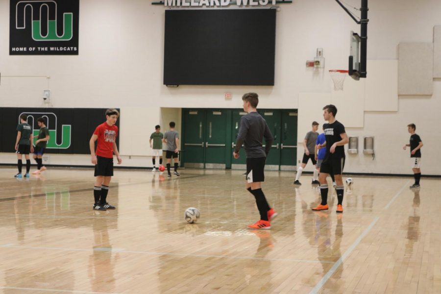 Varsity boys soccer team practicing their passing  skills inside. 