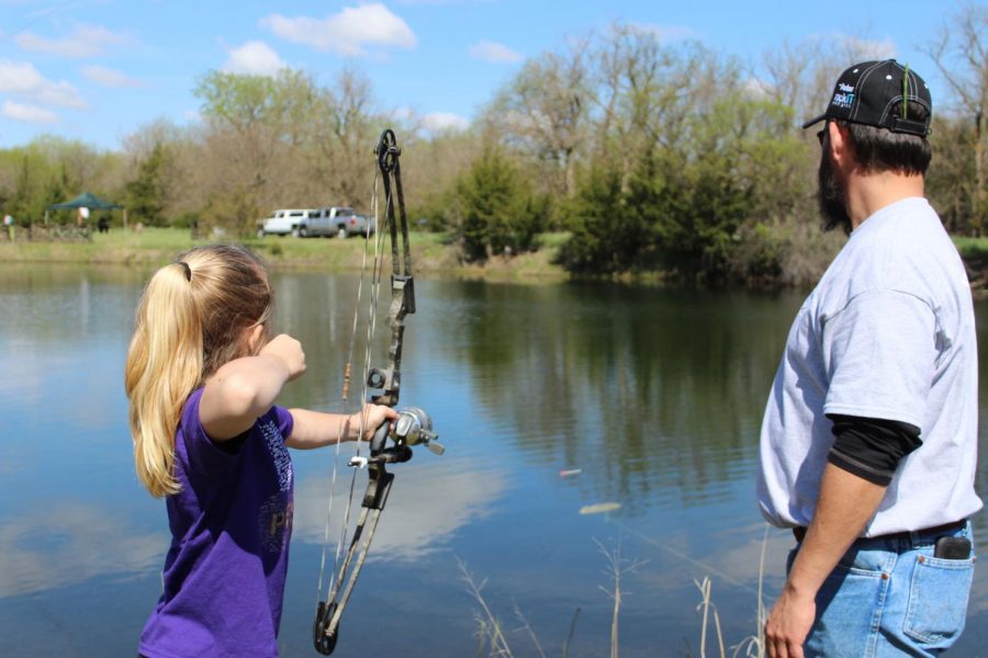 Kearney Outdoor Exploration Expo volunteer instructs student how to use bowfishing equipment. "I love teaching kids how to bowfish because its a moment they will remeber forever," volunteer Alex Gonzales said. "When they think back on life they won't go 'Remeber that day in math class but rather 'Rember when we learned how to bowfish?'.