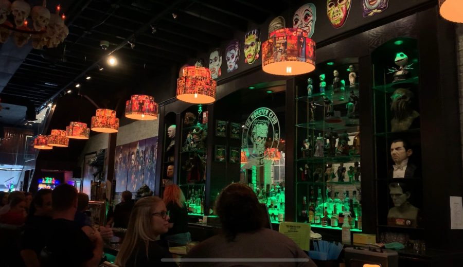 The Monster Club is filled to the brim with some intriguing decor. Here at the center is the main bar area  that contains a large, glowing sign of their brand. The center area is also surrounded by heads of many famous horror movie characters. 