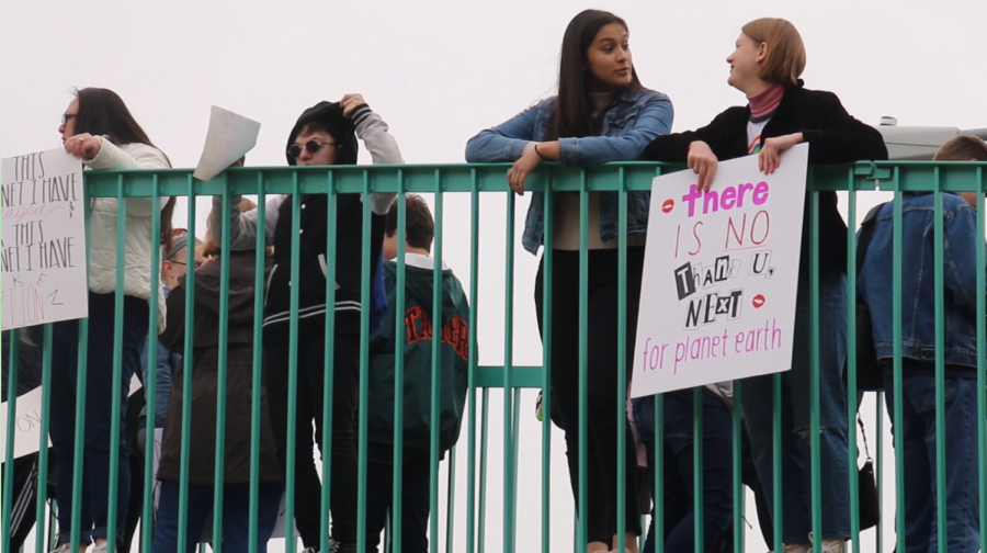 Students hold signs on the Dodge Street Bridge advocating for climate change awareness. They made signs and listened to speakers to prepare for this rally. "I wanted to get involved because it is very important to make sure you know your impact on the environment," senior Amelie Cole said. "As the human population grows, the impact is getting worse."