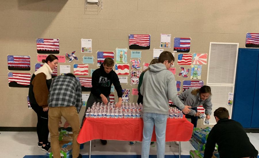 Students+are+setting+up+water+for+the+Veterans+Day+Performance.+They+volunteered+their+time+to+give+back.