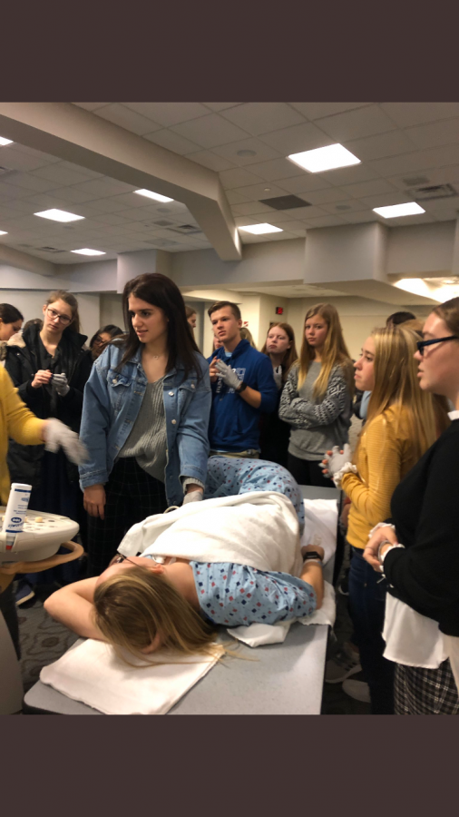 Students take turns using the sonogram on nurses within the building.
