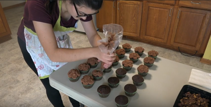 After creating the cake base for her cupcakes, senior Alissia Graybill must decide how she will choose to decorate. Here, she demonstrates her piping skills as she finishes her Chocolate Reeses cupcake with her decedent chocolate frosting. She then tops the cupcake with bits of the chocolate peanut butter candy. One of the best parts is finishing the cupcake with frosting and toppings, Graybill said. I have about 30 different piping tips that I can use to decorate. I want to get into fondant in the future and play around with that in addition to the frosting. 