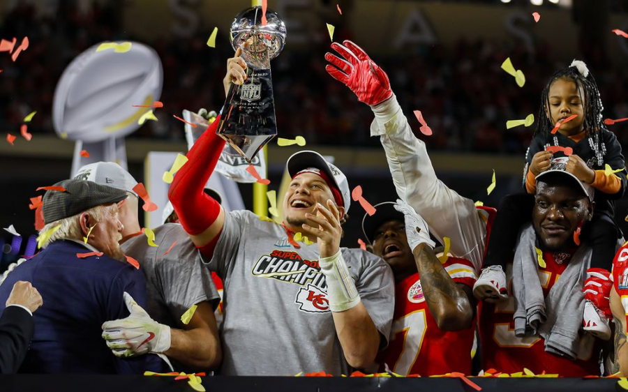 Chiefs quarterback Patrick Mahomes (middle) raises the Lombardi trophy as the Chiefs celebrate their first Super Bowl win in 50 years. Defensive end Frank Clark (far right) celebrates with his daughter on his shoulders.