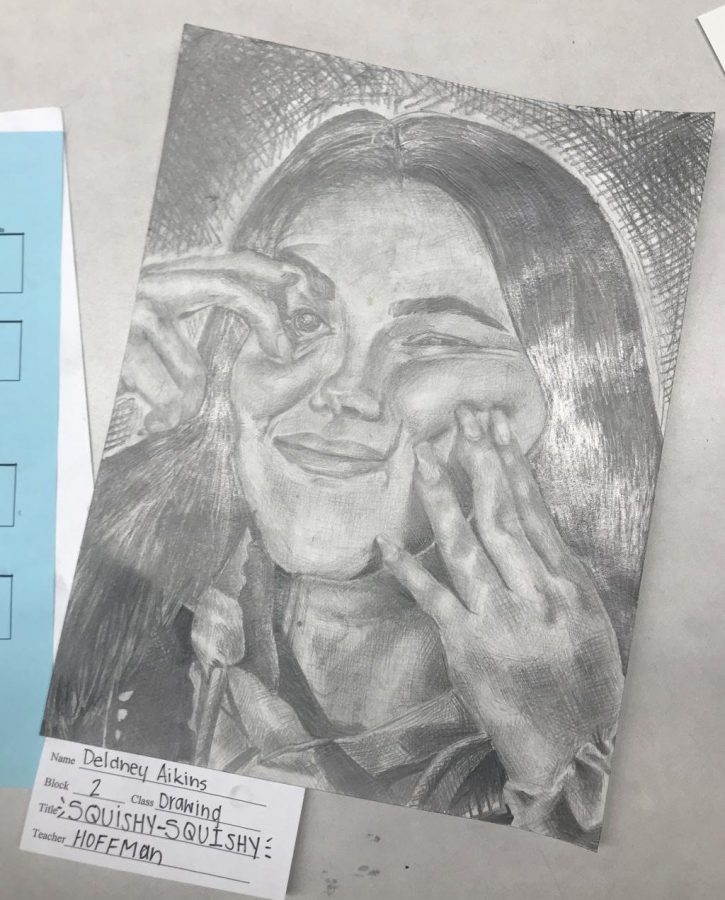 Junior Delaney Aikins worked on a self portrait drawing developing skills in shading and depth for the piece. In the Scholastic Art & Writing competition, the work received a Silver Key. “For the ‘Squishy Squishy’ drawing, we were supposed to stand there and smile so I asked Hoffman if I could mess with my face,” Aikins said. “Most of the other students went along with what we were doing in class but sometimes I like to spice it up.”
