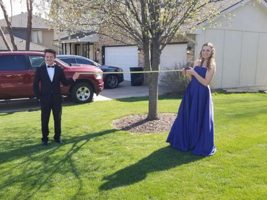 Tomm Bigler and his date, Mae Killeen keep social distancing while taking pictures to recreate their prom night. 