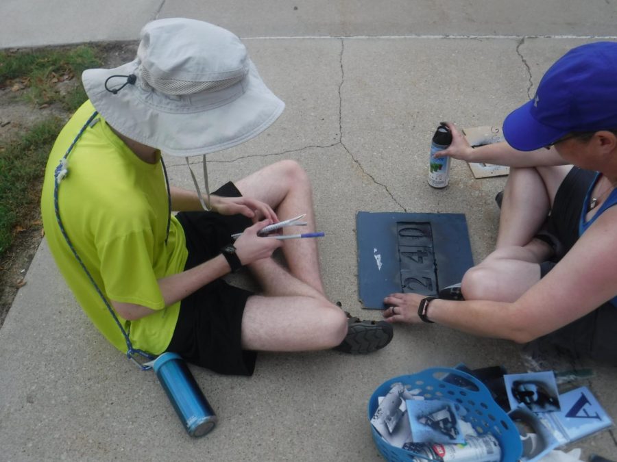 Junior Zachary Neesen and volunteers work to paint the room numbers used during fire drills on the sidewalks outside of Millard West high school. “On the day of the project, I assigned areas for the volunteers and gave them the needed supplies,” Neesen said. “Then during the project, I checked in with my volunteers repeatedly and offered any help I could.”
