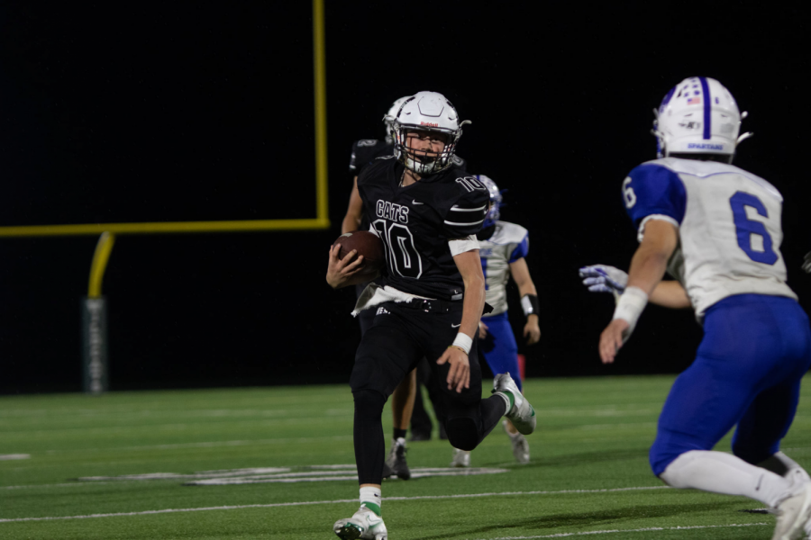 Sophomore quarterback Brady Brau evades defenders on a run. Friday night was his first start on varsity, and he threw for 25 yards while rushing for 63 yards. “I loved watching Brady Brau step up at the quarterback position,” senior linebacker Will Ekborg said. “He kept his cool the entire game and really looked like he knew what he was doing out there.”