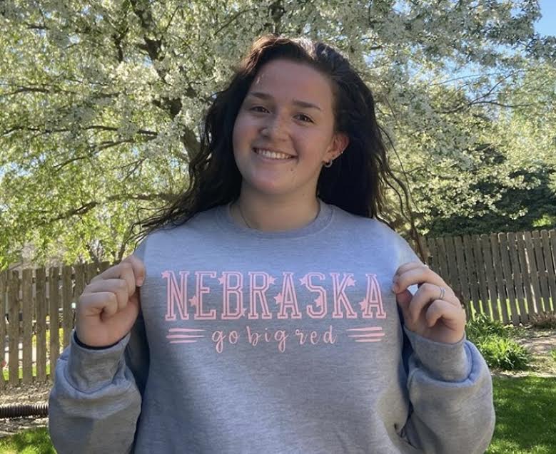 Senior Olivia Peterson poses in a sweatshirt that she designed and made herself. This picture also appears on her Instagram account, where she advertises her custom designs to others. “Nebraska related shirts are probably my most popular request,” Peterson said. “I think those shirts have been successful just because they are much cheaper than what you would find in a Husker store, but they are still high quality. I can print just about anything as long as its not a school affiliated logo that has copyright.”