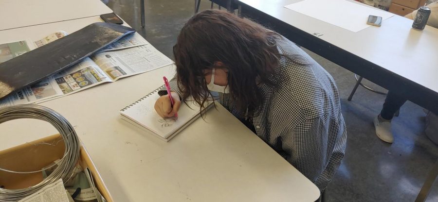 Senior Ceibhionn Stevens sketches out the designs for her mural. “The planning process was less difficult than I imagined,” Stevens said. “I looked up art of theater through history to gather ideas and inspiration. Then I made several drafts and had a few ideas that I eventually dropped in order to make the mural open and bright and true to our theater troupe.”