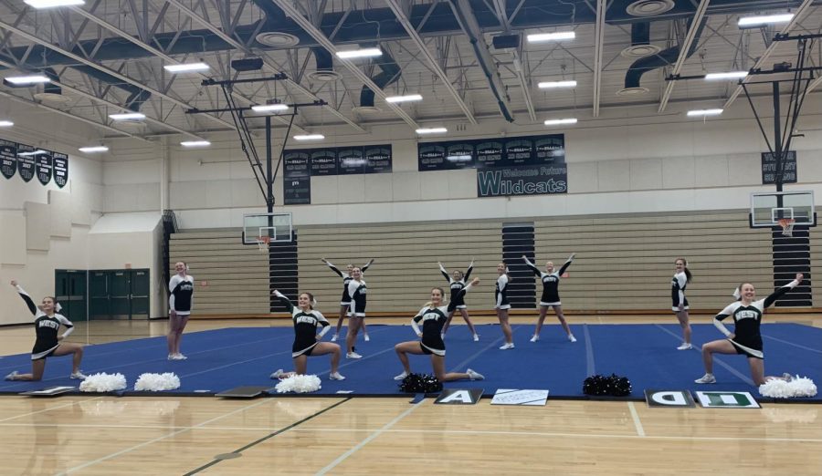 The varsity team strikes their first pose in their Tumbling, Non-Building routine. For their first competition of the season being completely virtual, the girls look forward to hopefully being able to compete in person. “I think it makes it a little harder to get a feel for what a comp day is really like, especially for the freshman,” senior Delaney Cutler said. “Luckily on the showcase night, we had a good amount of people in the crowd yelling with us which really helped us out.” 
