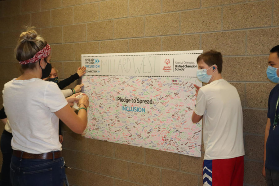 Special Education teacher Sara Wiese-Johnson assists her students in hanging up the inclusion poster outside of the ACP classrooms. “Today’s youth are leading the way in empowering change and we know when we #choosetoinclude, we are all better together and perceptions change,” Wiese-Johnson said. “The sign provides a visual reminder that if we all work together we can engage and activate this strategy and promote school communities of respect and dignity.”