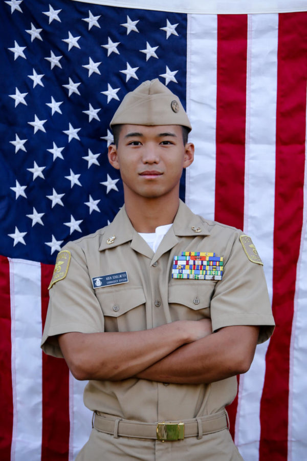 Standing+in+front+of+an+American+flag%2C+senior+Aiden+Schollmeyer+poses+for+a+photo.+He+hopes+to+attend+the+Naval+Academy+and+enter+the+Navy+after+high+school+before+he+enters+the+medical+field%2C+but+for+now%2C+he+is+taking+steps+to+prepare.+%E2%80%9CIm+still+working+out+and+working+long+days%2C+as+well+as+learning+different+leadership+styles+and+traits+from+several+resources+available+to+me%2C%E2%80%9D+Schollmeyer+said.+%E2%80%9CThe+Naval+Academy+will+give+me+a+Bachelors+in+science+and+hopefully+the+Navy+will+allow+me+to+pursue+a+medical+career+later+in+life.%E2%80%9D%0A