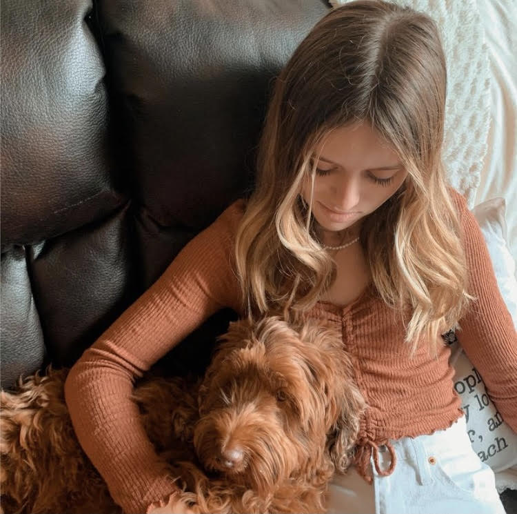 Freshman Lily Dotson cuddles with her dog. She underwent two and a half years of intense treatment. We are so thankful she continues to be a warrior even when people don’t see the battle, mother Susie Dotson said. We are proud of all she has overcome.