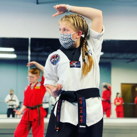 While training after earning her second-degree black belt, sophomore Olivia O’neill stands in a defensive block position. Training at Omaha Blue Waves since she was five, O’neill is now training to achieve her third-degree belt, or the Sam Dan. “Practices, or classes, throughout the week focus on multiple different things,” O’neill said. “Weekday classes lean more towards traditional martial arts, in other words, everything you will need to advance to the next rank. Saturday classes consist of more extreme martial arts. This is reserved for tumbling classes, classes to make creative forms, and weapons classes.”