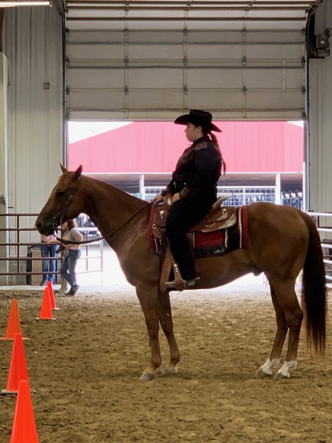 Senior+Lizzie+Ward+maneuvers+through+cones+during+a+western+horsemanship+competition.+She+has+been+competing+in+equestrian+since+the+age+of+6+and+has+won+six+ribbons.+%E2%80%9CI+have+always+had+a+love+for+horses%2C+so+when+I+turned+6+my+grandma+had+started+me+in+riding+lessons%2C%E2%80%9D+Ward+said.+%E2%80%9CThat+is+how+my+interest+in+riding+really+started.%E2%80%9D%0A