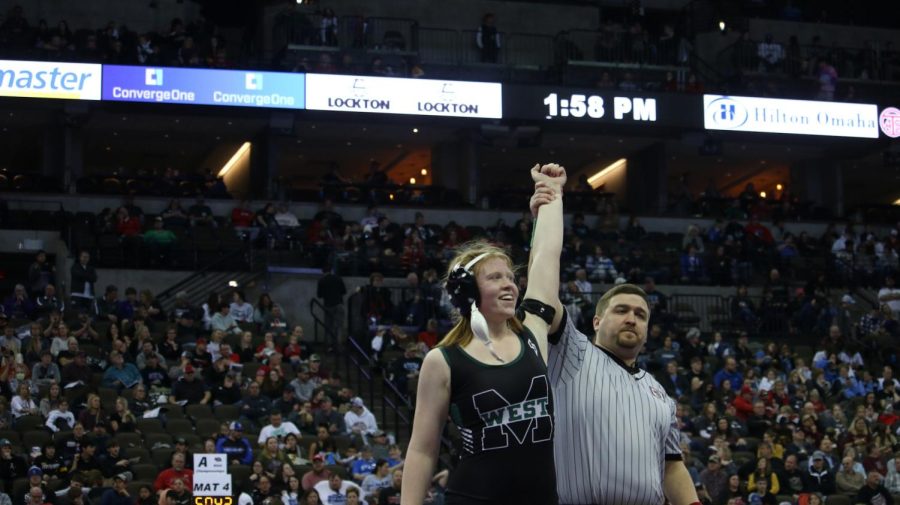 Freshman Lauren Sash gets her hand raised after a victory in the first round of state.
