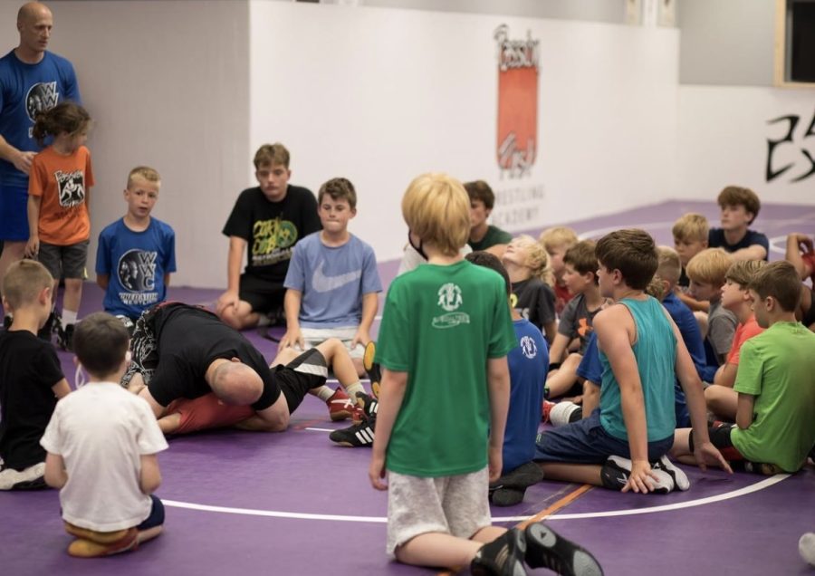 Passion First Wrestling Academy athletes gather to listen to coach.