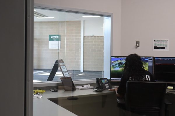 Security guard Corri Pike sits in the new security office, which is now able to unlock one of the inside and outside doors remotely.