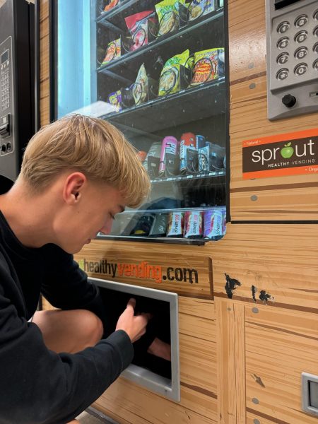 Senior Holden Clausen goes to one of the three vending machines at the Green Mile hallway. My go to snack are definitely the hot fries, Clausen said. I go to the vending machines during first block every single day.