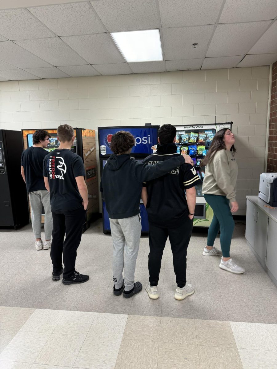 Students congregate outside of the Green Mile vending machine during first block. Waiting in line for everyone to get their items can be a hassle, senior Delaney Lueck said. If i dont want to wait for everyone to get their items, Ill come back another time.