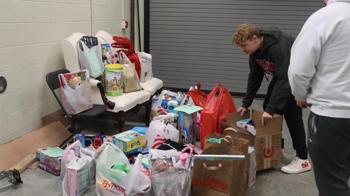 Students+stop+by+the+band+hallway+to+donate+gifts+for+children+in+need.+There+were+30-40+gift+donations+and+an+envelope+full+of+gift+cards.