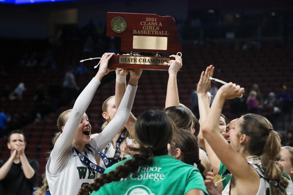 After+winning+the+State+Championship%2C+the+Millard+West+varsity+girls+basketball+hoists+the+trophy+up.+They+would+finish+the+season+27-1+and+State+Champions+after+defeating+Bellevue+West+58-55.+%E2%80%9CIt+means+everything+to+win+a+State+Championship+my+senior+year%2C%E2%80%9D+senior+Taylor+Hansen+said.+%E2%80%9CI+had+dreamed+for+years+of+being+able+to+cut+the+nets+down+at+PBA+and+to+finally+be+able+to+get+it+done+with+my+teammates+was+something+Ill+never+forget.%E2%80%9D