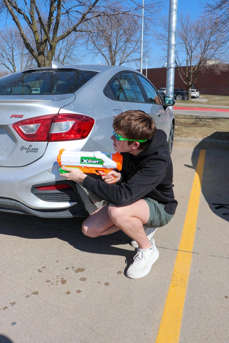 Scouting out in the parking lot, senior Nate Buroker prepares to eliminate his target in a sneaky manner. Buroker found out when his target had class which made it a perfect time to make his move. One of my teachers were able to give me the schedule of my target which helped me know when they would arrive and leave, Buroker said. The parking lot is an easy way to ruin somebodies day.