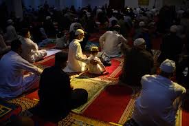 Muslims praying taraweh in rows in the dark. They pray next to each other for at least an hour. 