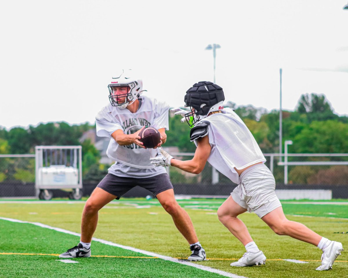 Handing the ball off to his teammate, senior quarterback David James Schiemann practices in preparation for week one. This year will be Schiemann’s first at the helm of a new Millard West offense after sitting behind former starter Brody Peterson. “Stepping into the starting role has been on my mind since last season ended,” Schiemann said. “Being behind a quarterback like Brody for a long time with his leadership and ability to tell me things to prepare has helped me to be the guy to lead this new offense this year. While this summer has been going alright, I know the coaches are always helping me in every way to help not just myself but the others around me, too.”