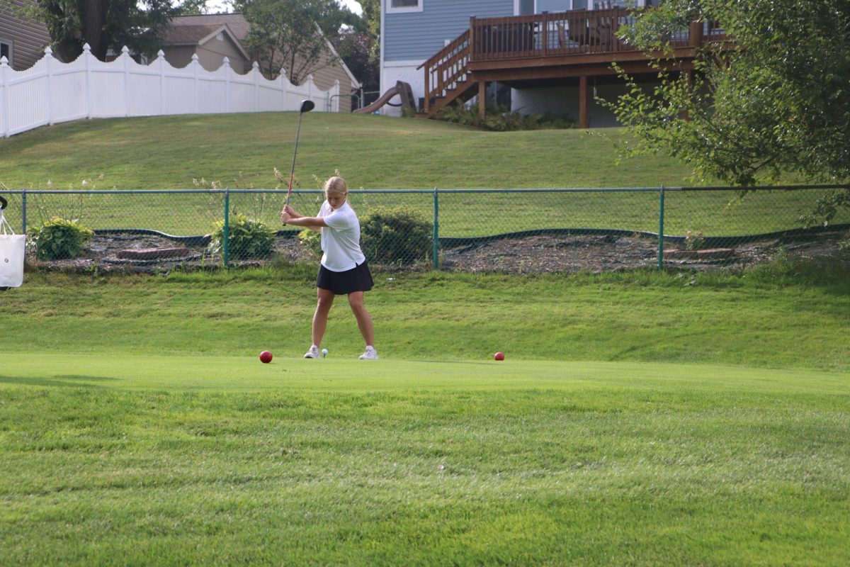 During the round, sophomore Jaelynn Moody takes a swing toward the golf ball. The team warmed up at the range and met to talk about their daily goals for the tournament ahead. ”My favorite thing about golf is my teammates for sure,” Moody said. “ I also love being able to meet a couple people from different schools and then getting to play against them.”