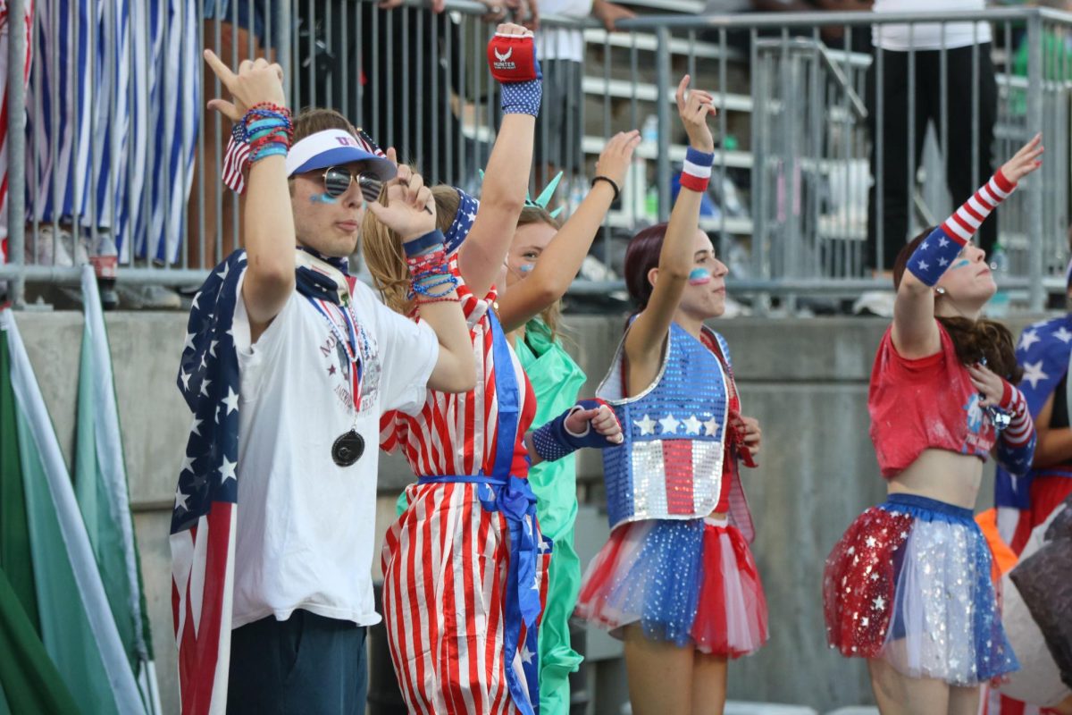 Cheering on the football team, senior Frederick Mindrup dresses up with necklaces, bracelets and an American flag cape to help lead chants and show school spirit. He and 15 other crazies pumped up the crowd and made the most of the first football game this season. “During football games, we are responsible for the crowd,” Mindrup said. “This means that we need to keep the energy flowing if it seems too mellow. We help lead chants with the cheerleaders and encourage the crowd to get loud.”