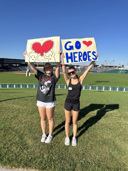 Before the run begins, senior Chloe Teter and junior Montana Chronister pose for a picture with the handmade signs they made to cheer on the kids. Children dressed up as superheroes for the run to demonstrate the strength people have when fighting through Congenital Heart Disease. “I decided to participate with DECA for the Heart Hero Run because I wanted to volunteer and have fun with the kids with fun activities,” junior Montana Chronister said. “Heart Heroes impacted me because it was so great to see such a close community of people supporting one another.”