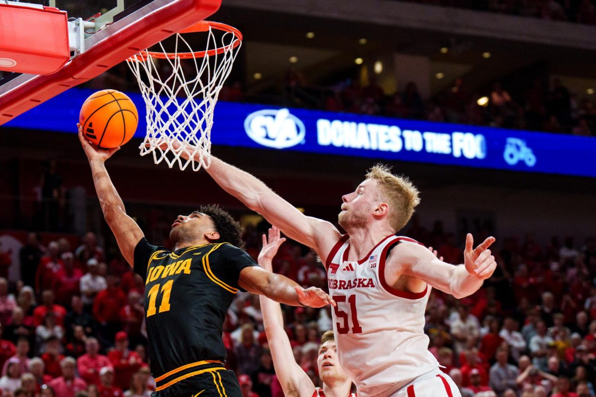 Mar 8, 2026; Lincoln, Nebraska, USA; Iowa Hawkeyes guard Kael Combs (11) shoots the ball against Nebraska Cornhuskers forward Pryce Sandfort (21) and forward Rienk Mast (51) during the second half at Pinnacle Bank Arena. Mandatory Credit: Dylan Widger-Imagn Images